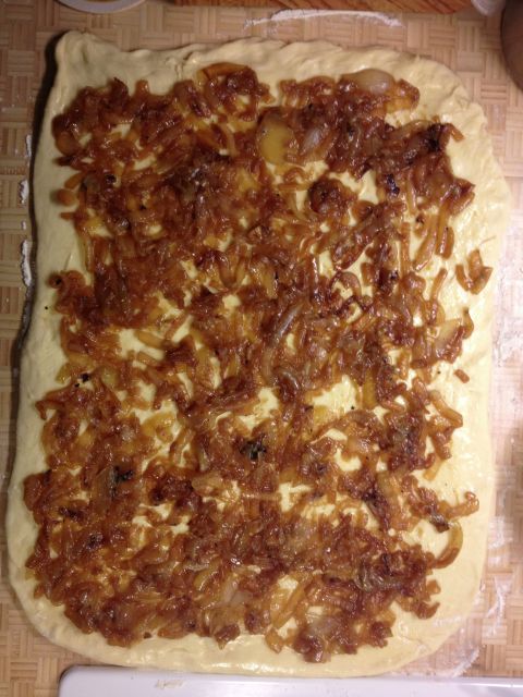 Spread caramelized onions evenly over the dough's surface.